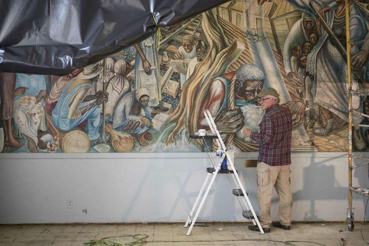 Art restorer Scott Haskins works on the mural titled "The Contribution of the Negro Woman in American Life and Education," Monday, Jan. 14, 2019, in Houston. The mural was created by Dr. John Biggers in 1953 and is located at the Blue Triangle Community Center. The mural was severely damaged by Hurricane Harvey.
